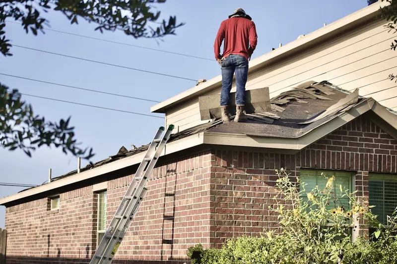 Professional roofer working on a residential roof in Adams-Normandie